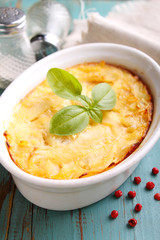 Casserole with fish in a white dish on a blue background