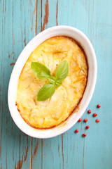 Casserole with fish in a white dish on a blue background