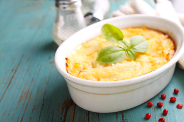 Casserole with fish in a white dish on a blue background