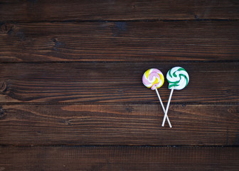 Round delicious lollipops on a wooden background. 