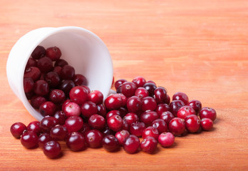 White cup with cranberries spilling out of it