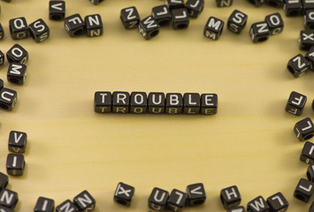 The word trouble on wood background