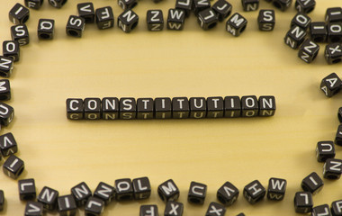 The word constitution on wood background