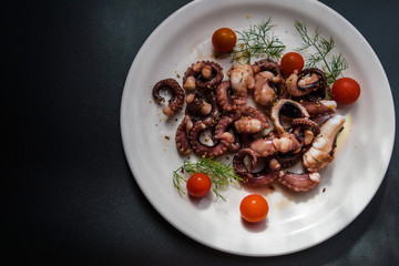 fried in olive oil, octopus tentacles with cherry tomatoes and spices