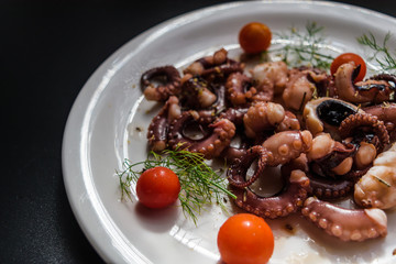 fried in olive oil, octopus tentacles with cherry tomatoes and spices