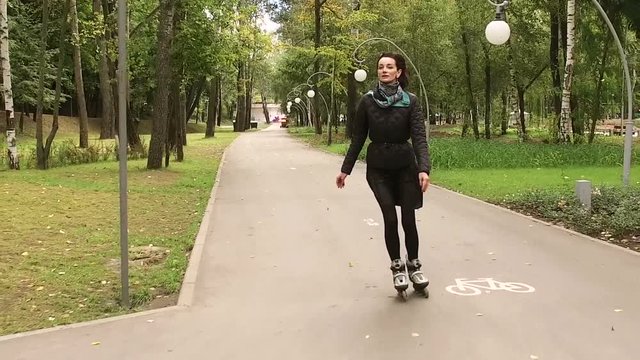 Rollerblading. Dark-haired stylish woman moving on rollerblades. Slow motion. HD