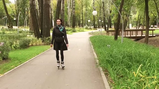 Roller-blading. Dark-haired stylish woman moving on rollerblades. Slow motion. HD