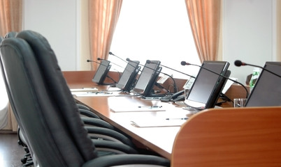 Wooden table with monitors and microphones in press-center