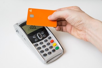Customer is paying using contactless credit card and payment terminal.