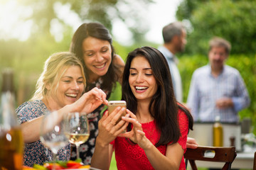 Group of female friends having fun while they watch photos