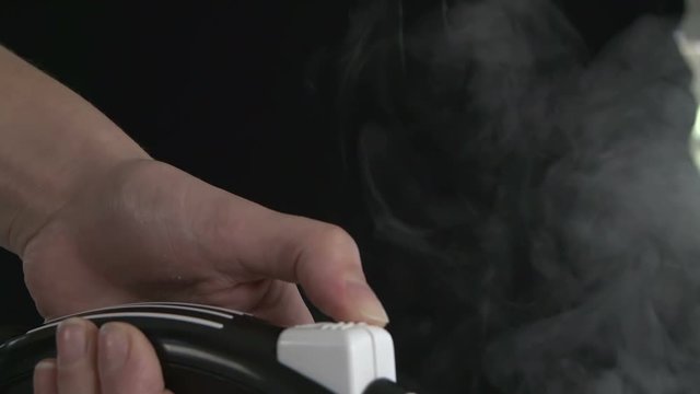 Woman using a hot steamy iron