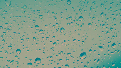 Rain drops on the car glass with vintage filter and blurred background
