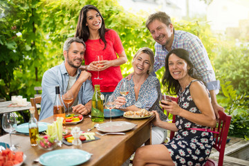 Group of friends gathered around a table on a summer terrace