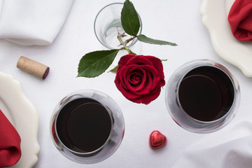 Red Wine with the Bottle, Cork, and a Rose on White Linen