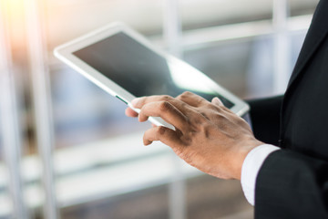 Business concept with man hand touching tablet computer