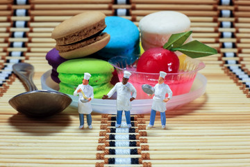 Group of cook are standing in front of desserts for presenting their menu.