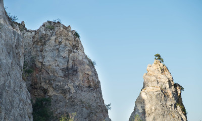 Mountain peaks covered and cliff with forest and bright sky with a white cloudy.