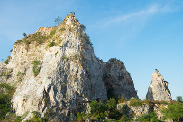 Mountain peaks covered and cliff with forest and bright sky with a white cloudy.