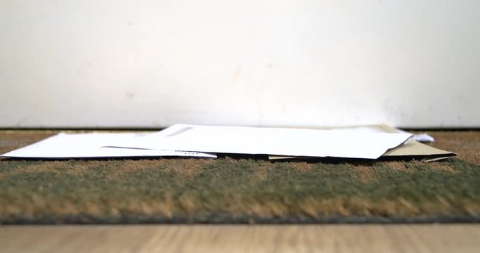 Household bills falling on a door mat