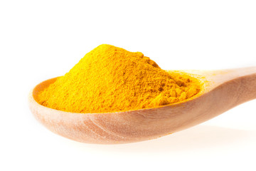Close up dry turmeric powder in wooden spoon on white background