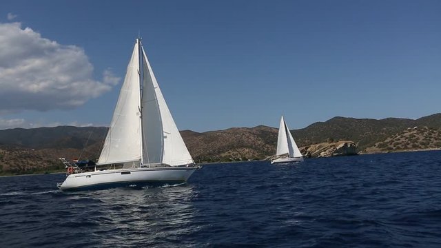 Sailing ship boats with white sails in the Sea. Luxury yachts.
