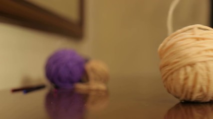 The girl unwinds the skein of beige yarn close-up.