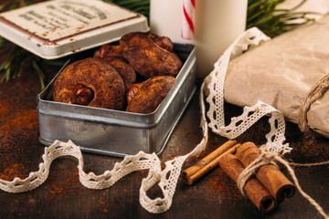 Food background of cinnamon cookies with hazelnut, bottle of milk and candy cane on dark brown rusty table
