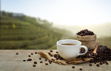 Hot Coffee cup with Coffee beans on the wooden table and the pla