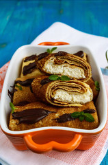 Pancakes with curd, chocolate, mint leaves decoration on a blue background. Vertical view