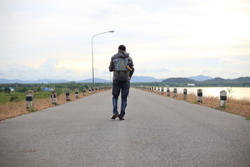 Man walking on road of dam in Pra Sae Reservoir at Rayong, Thailand