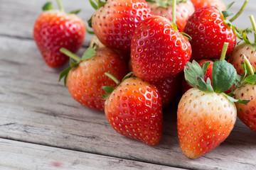 Strawberries with leaves on a wooden background