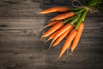 Red carrot on wooden background table.