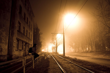 Naklejka na ściany i meble One man on the foggy street at night