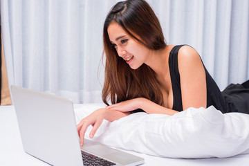 Obraz na płótnie Canvas woman and laptop on bed, woman and notebook on bed, woman and computer