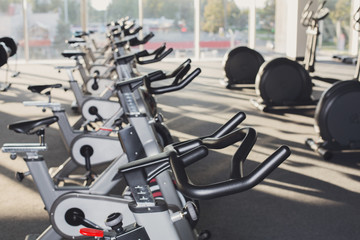 Modern gym interior with equipment, fitness exercise bikes