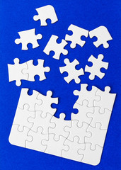 White puzzle elements on a blue background.
