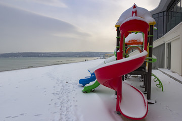 colorful children playground on the beach in snow