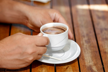 Mans hands with cup of hot coffee