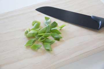 bunch of fresh spring onions a cutting board