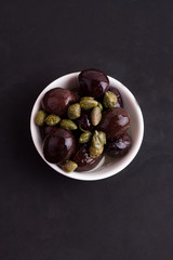 olives and capers on a black background