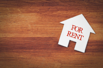 house for rent symbol with wood background