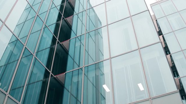 Close-up low angle steadicam shot of modern glass facade office building in Paris. 4K video