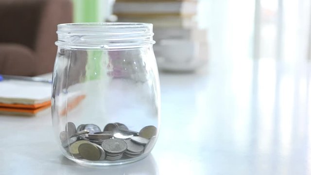  4K Time lapse of increase money coins in the glass jar