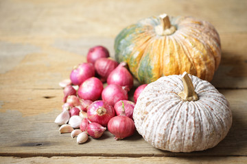 Pumpkin and onion and garlic on wooden table