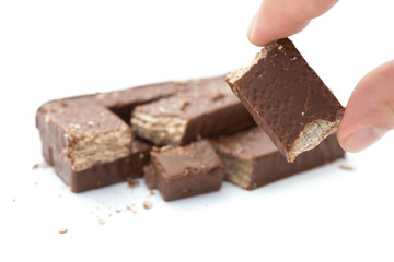 hand holding a chocolate wafer section on a white background