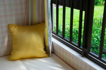 resting area of a cozy window seat with gold cushion in the morning horizontal composition