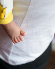 newborn baby foot next to mothers body