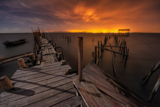 Aged wooden pier in sunset lights