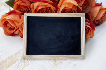 empty black chalkboard with orange roses