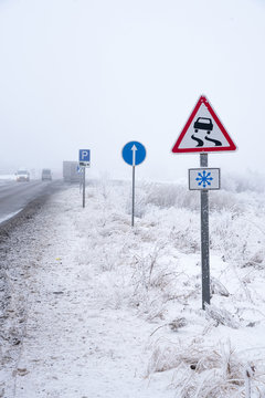 Winter Road With Road Sign Of Slippery Road, Parking.